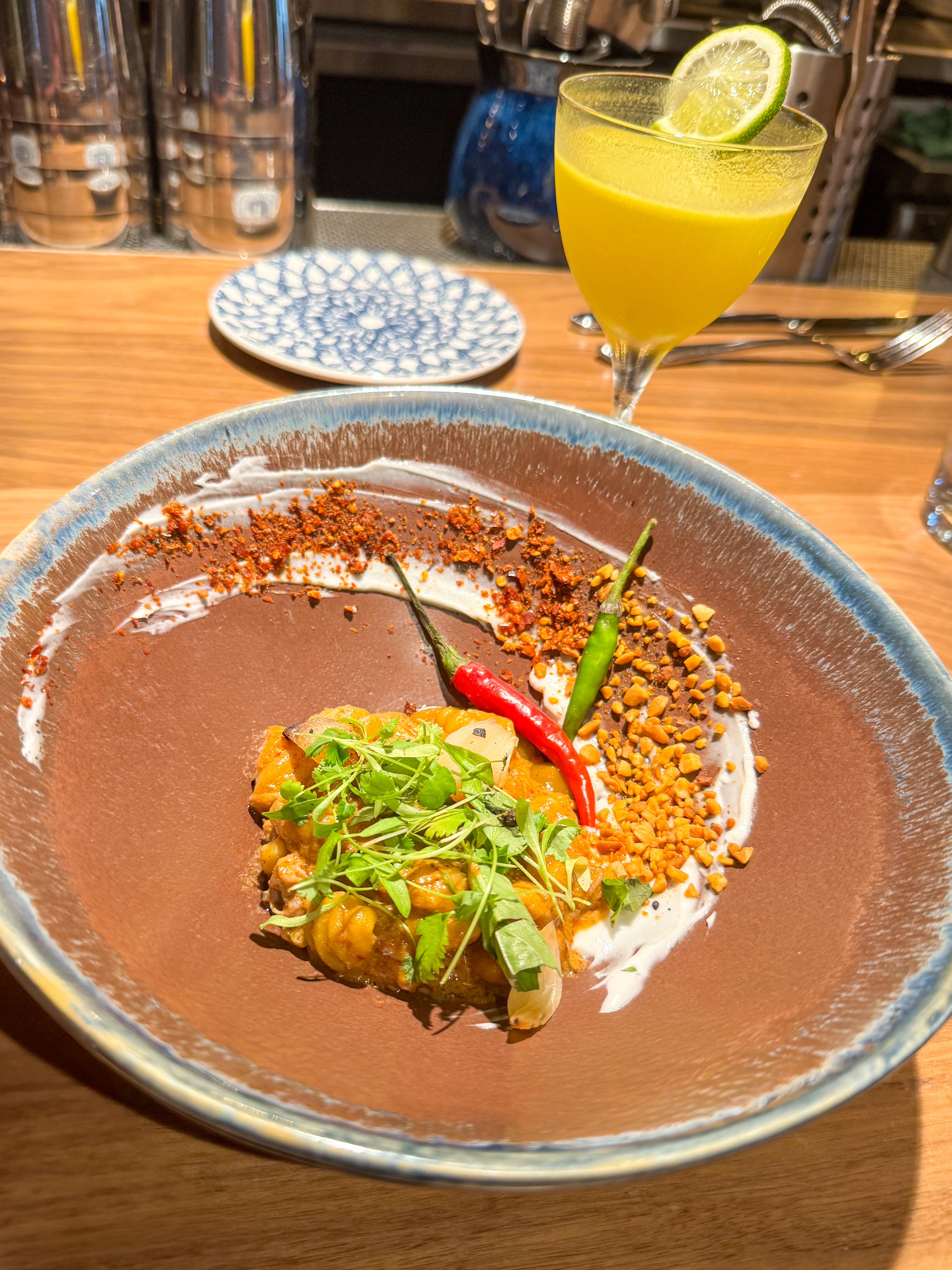 Beautifully presented dessert or breakfast bowl with dark base, topped with cream, colorful fruit medley, and garnished with red chili pepper