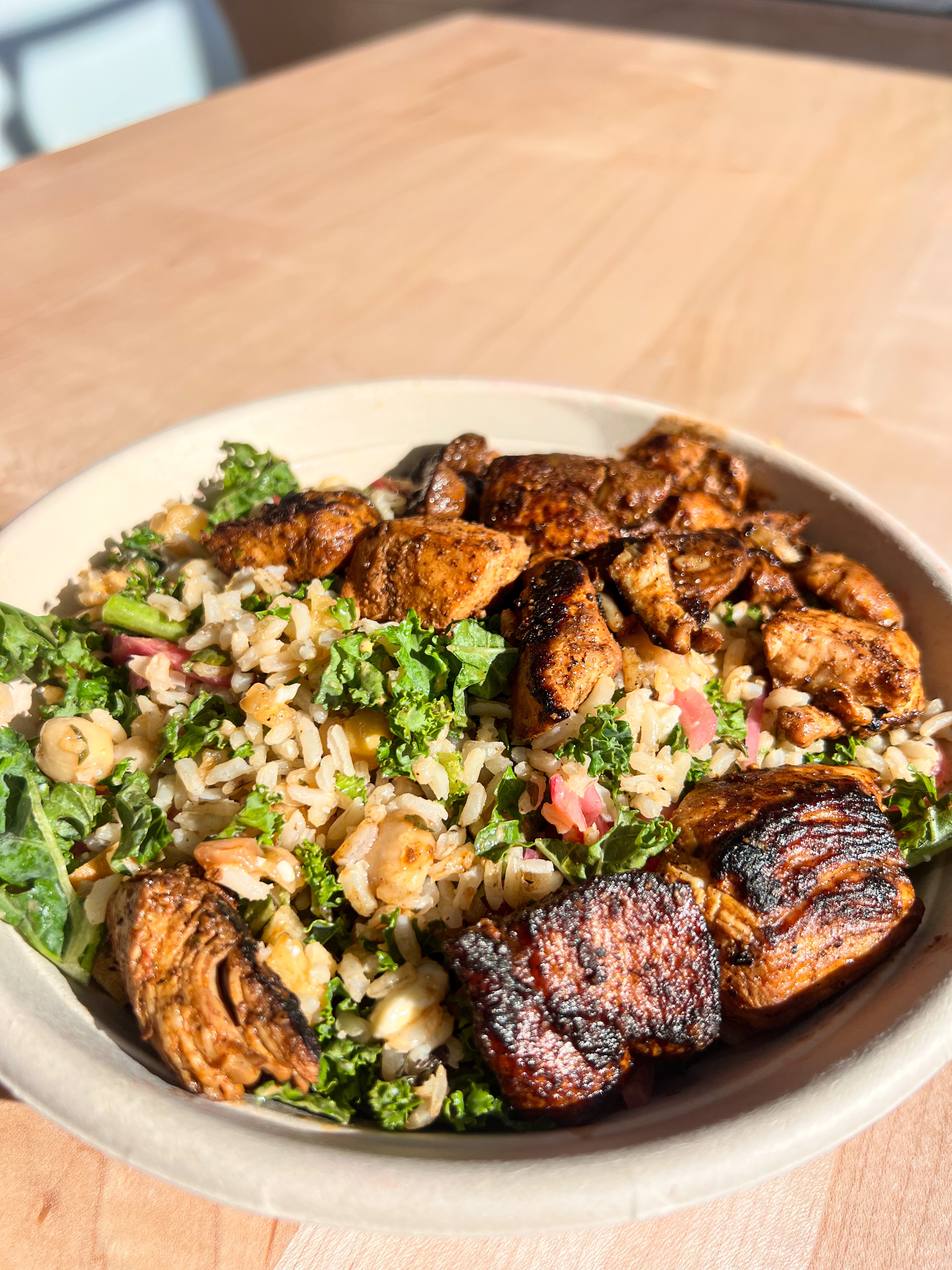 Wholesome salad bowl with mixed greens, couscous or quinoa, roasted Brussels sprouts, and grilled chicken