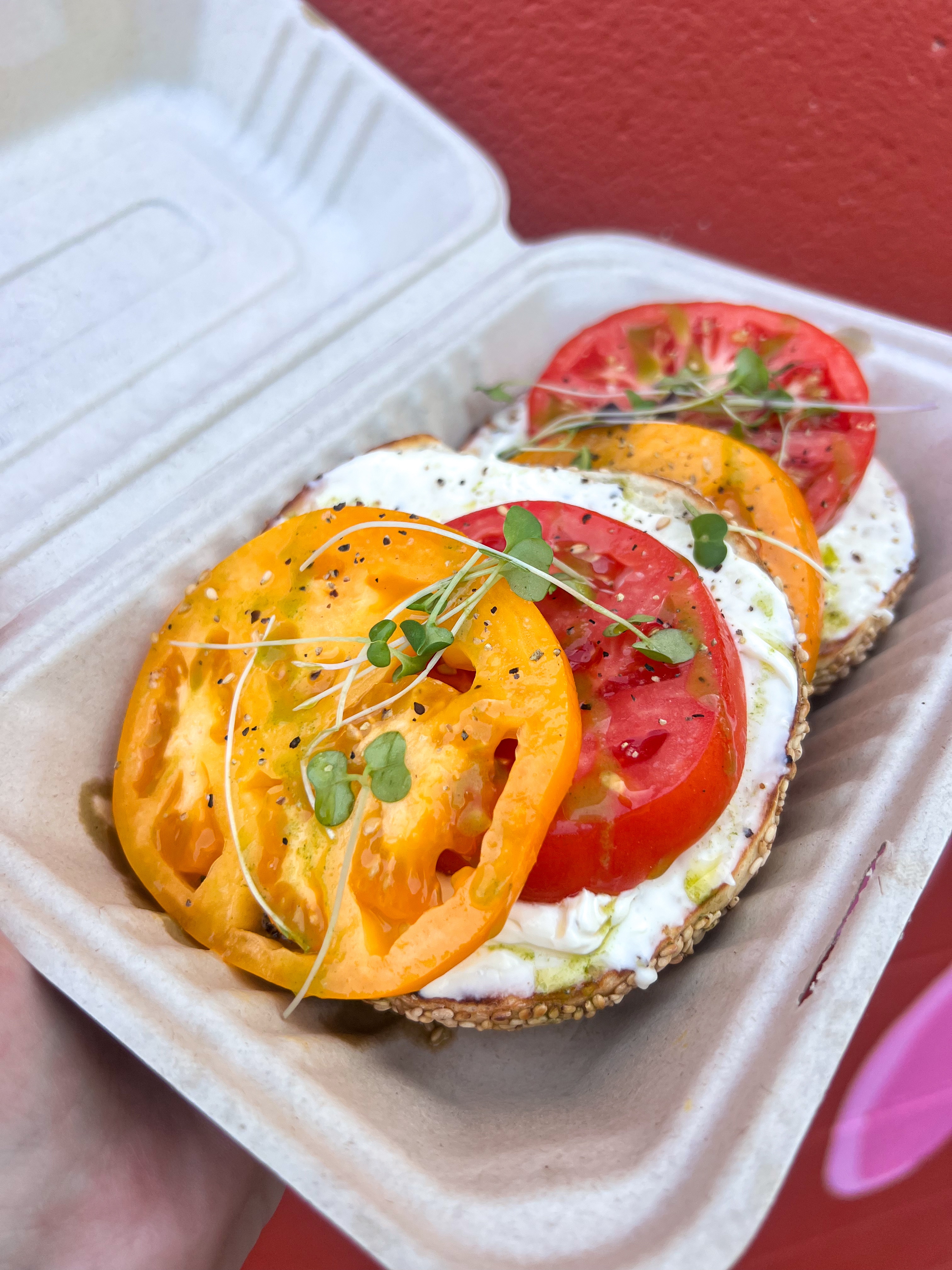 Vibrant caprese-style salad with thick slices of red and yellow heirloom tomatoes layered with fresh mozzarella or burrata